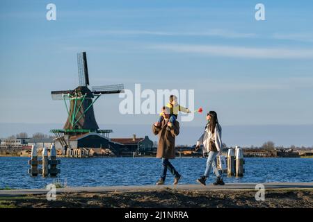 (220327) -- ZAANSE SCHANS, March 27, 2022 (Xinhua) -- People tour the Zaanse Schans neighborhood in Zaandam, the Netherlands, March 26, 2022. Zaanse Schans is a neighbourhood best known for its collection of well-preserved historic windmills and houses in the Netherlands. (Xinhua/Zhang Cheng) Stock Photo