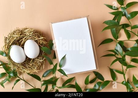A mock-up of a kraft envelope with a white sheet of paper and eggs. Eco-Easter. Zero waste. Lifestyle without plastic. Stock Photo