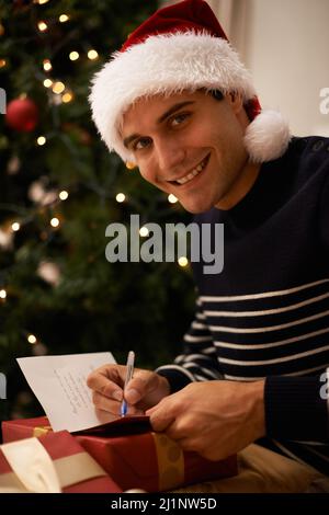 Playing Santa. Shot of a handsome young man getting ready for ChristmasShot of a handsome young man getting ready for Christmas. Stock Photo