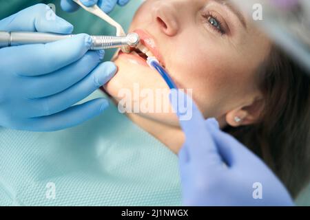 Dentist performing dental procedure with dental drill Stock Photo