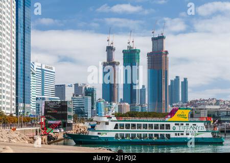 Busan, South Korea - March 17, 2018: Haeundae district landscape with ferry ship, it is one of the most famous and beautiful beaches in Busan Stock Photo