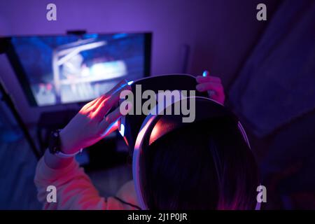 Woman interacts with virtual reality using a vr headset. Concept of virtual reality, futuristic entertainment and communication. Stock Photo