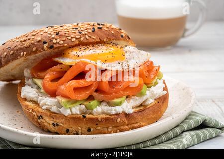 Bagel sandwich with salmon, cream cheese, avocado and egg. Stock Photo