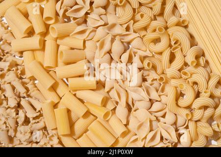 Different types of raw pasta on a textile background Stock Photo