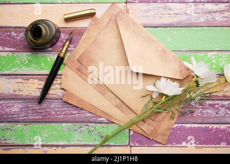 stack of envelope , flower and fountain pen on table  Stock Photo