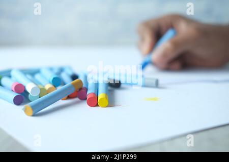 Color pencils on yellow papers on table  Stock Photo