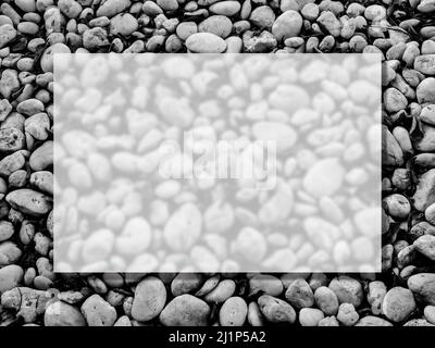 A transparent glass square border frame on the many white beach gravel stones texture surface background, top view. Empty blank space for summer, vaca Stock Photo