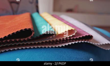 Close-up colorful upholstery fabric samples on blue background. Example for fabric catalog. Selective focus. Stock Photo