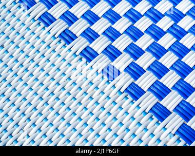 Abstract white and blue rattan pattern background. Close-up checkered pattern caused by the interweaving of white and blue lines, top view. Stock Photo