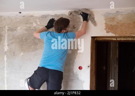Man washing walls from dust using old rag Stock Photo