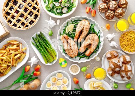Easter festive table with salmon, asparagus, salad, potato, muffins and berry pie Stock Photo