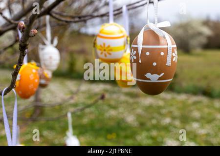 Happy Easter! Easter decorated eggs. Garden tree set up with multicolored Easter eggs. Stock Photo