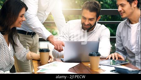 Taking their discussion beyond the boardroom. Shot of a group of businesspeople having a meeting at a cafe. Stock Photo