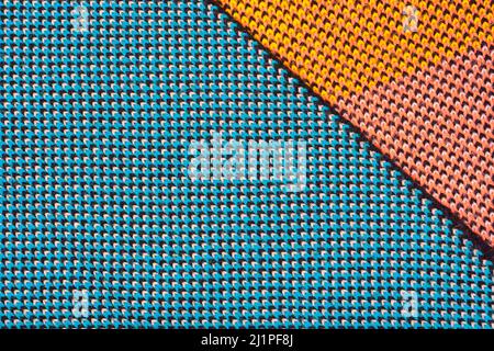 A pile of multi-colored synthetic knitted fabrics of different structures and textures. A stack of colorful fabrics smooth shapes background. Multicol Stock Photo