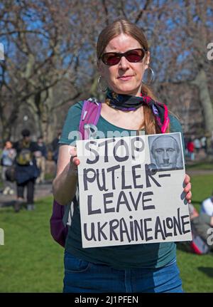 Supporters stand in solidarity with people of Ukraine, Meadows, Edinburgh, Scotland. 27th March 2022. Around 100 people of all ages turned out to support the local Ukrainians and other nationalities who have families and friends in Ukraine. Weather 17 degrees centigrade.  Credit: Arch White/alamy live news. Stock Photo