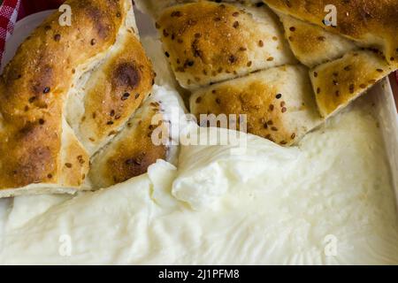 Two slices of Traditional Turkish Ramadan Bread,Pide in fresh yogurt. Stock Photo