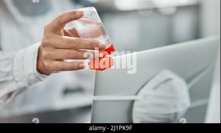 Safety before anything else. Cropped shot of a businesswoman using hand sanitiser while working at her desk in a modern office. Stock Photo