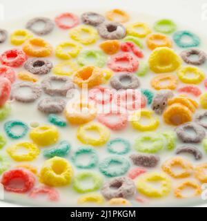 Quick breakfast cereals. Colored fruit rings in milk. Healthy baby food, school breakfasts, healthy lifestyle, healthy food. Abstraction. Close-up. Fo Stock Photo