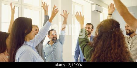 Banner with team of happy business people smiling and giving each other high five Stock Photo
