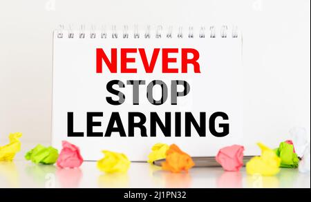 Never Stop Learning, handwriting quotation on notebook Stock Photo