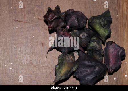 water caltrop fruit on the wooden background. Stock Photo