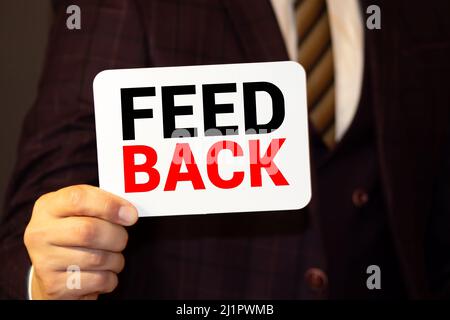 FEEDBACK word on the card shown by a man, vintage tone Stock Photo