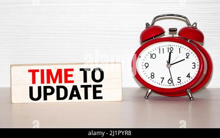 Alarm clock and text Time to Update. Time to Update concept. Time to Update concept clock closeup on white background with red and black words Stock Photo