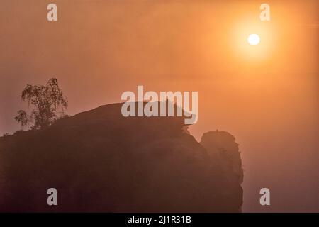 Rock formations covered in fog in Rathen area of the Saxon Switzerland National Park at sunrise. Stock Photo