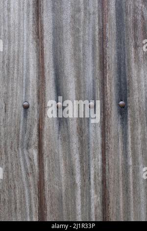 Vertical view of old gray planks of wood with large nail heads in a row texture background and wallpaper. Copy space. Stock Photo