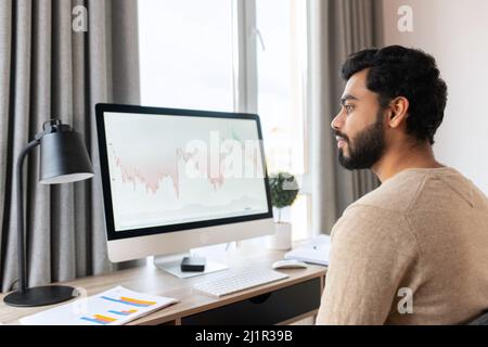 Businessman professional is working on project, writing email to client. Serious concentrated determined young bearded office worker in business casual clothes, sitting at the desk, typing on laptop Stock Photo