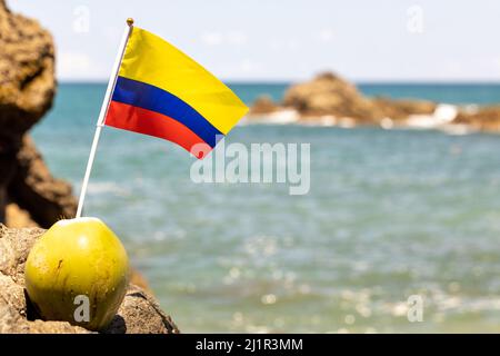 Holidays and life in Colombia Concept, Sunny beaches, nature, tropical fruits, leisure, Country flag sticking out from a fresh coconut on the backgrou Stock Photo