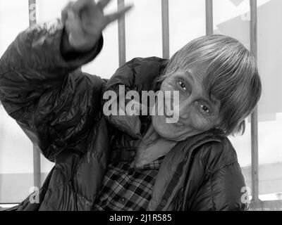 Old lady tramp smiling at camera whilst begging on the streets of Hong Kong. Stock Photo
