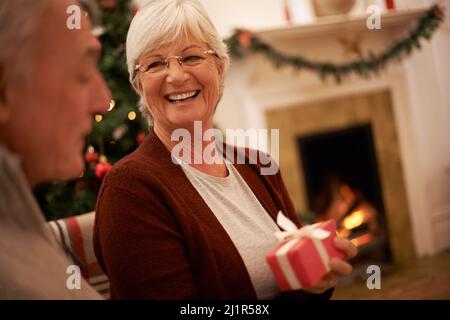 Special gifts on Christmas. Shot of a senior couple exchanging gifts at christmas. Stock Photo