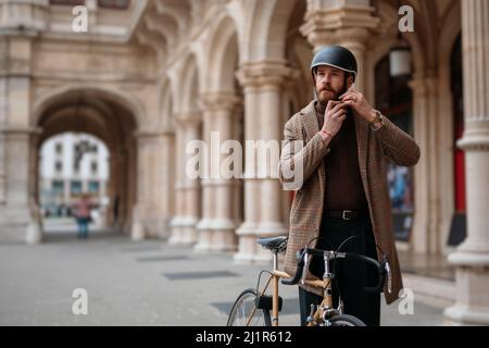 Hipster putting on a helmet. Safety bicycle transport Stock Photo
