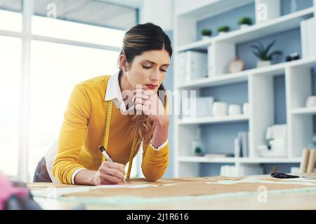 Life is about using the whole box of crayons. Cropped shot of an attractive young fashion designer in her workshop. Stock Photo