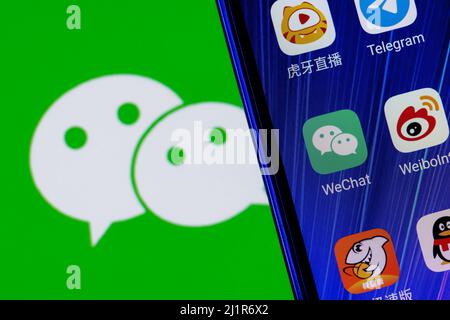 The icon of the WeChat messenger application among other applications on the smartphone screen Stock Photo