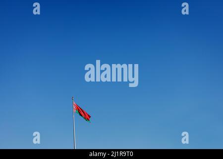 Flag of Belarus on flagpole waving against blue sky. copy space. belorussia flag Stock Photo