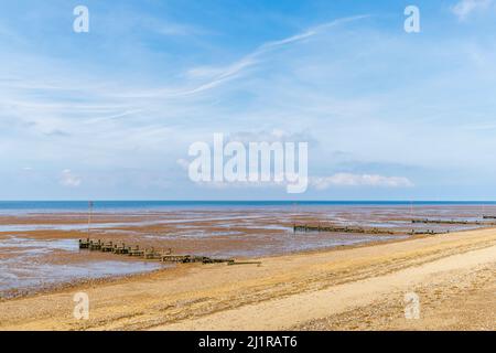 Wooden groynes on a deserted beach at low tide on the foreshore at Heacham, west Norfolk, England, overlooking The Wash Stock Photo
