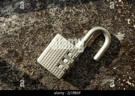 Open combination padlock on a distressed surface, USA  2022 Stock Photo