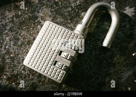 Open combination padlock on a distressed surface, USA  2022 Stock Photo