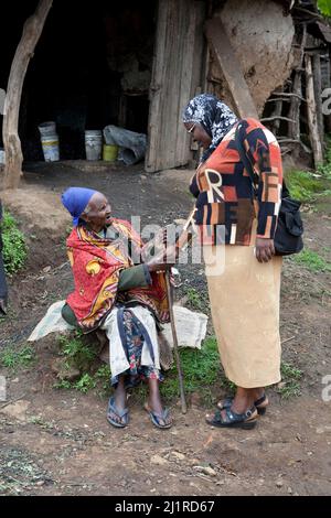 An aid worker greets a local friend, Majengo slum, Meru Stock Photo