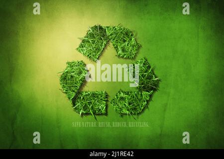 Recycling sign created from grass. Green grunge background. Reuse, reducing and processing concept. Stock Photo