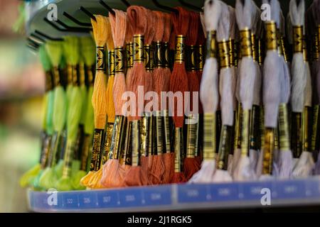 Thame,UK-Sept 2021: Various colors moulin threads hanging on store display, embroidery thread mouline for hobby and craft, popular for knotting Stock Photo