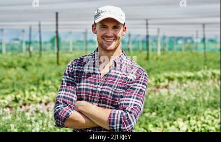 Farming has always been in my blood. Portrait of a handsome young farmer posing outdoors on his farm. Stock Photo