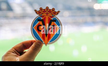 September 12, 2021, Villarreal, Spain. The emblem of the football club Villarreal CF against the background of a modern stadium. Stock Photo