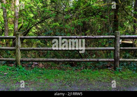 Three tier rail fence old in the middle of a park flat facing even proportions. Stock Photo