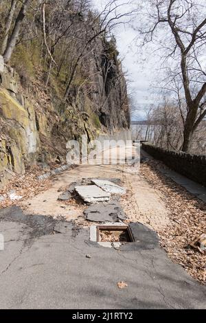 Aftermath of the hurricane, tropical storm Ida - damaged pavement on Dyckman Hill Road, Englewood Cliffs entrance to the Palisades Interstate Park, NJ Stock Photo