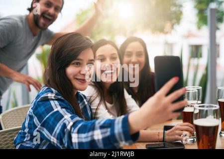Now thats a photo bomb. Shot of a cheerful young group of business work colleagues taking a self portrait together at a restaurant. Stock Photo