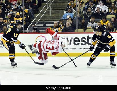 Pittsburgh, United States. 27th Mar, 2022. Detroit Red Wings left wing Lucas Raymond (23) falls to the ice while skating between Pittsburgh Penguins right wing Bryan Rust (17) and defenseman Mike Matheson (5) during the third period of the 11-2 Penguins win against the Detroit Red Wings at PPG Paints Arena in Pittsburgh on Sunday, March 27, 2022. Photo by Archie Carpenter/UPI Credit: UPI/Alamy Live News Stock Photo