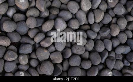 Naturally polished shades of gray stones gathered together and shot from above looking down on pile Stock Photo